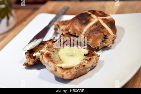 Toasted hot cross buns with butter for Easter Good Friday celebrations in UK Stock Photo