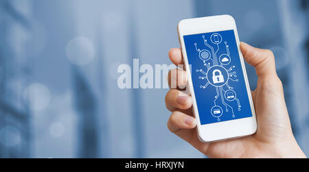 Cybersecurity concept with a person showing smartphone screen with cyber security icons in the shape of a electronic microchip circuit board and blurr Stock Photo