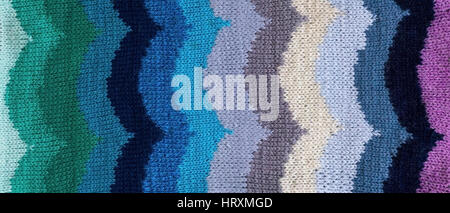 Knitted handmade fabric fragment with an ornament in the form of waves. Background Stock Photo