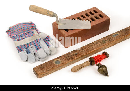 Old construction accessories trowel, bricks, plummet and level on white background. Stock Photo
