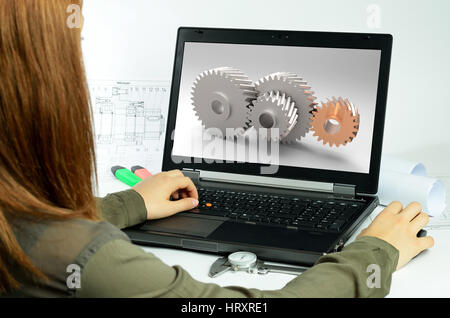 Young woman using CAD system in front of a laptop back view Stock Photo
