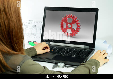 Young woman using CAD system in front of a laptop back view Stock Photo