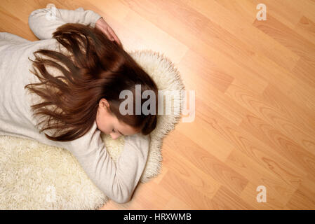Top view of young woman is sleeping on the floor Stock Photo