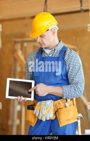 Construction worker pointing at digital tablet close-up Stock Photo