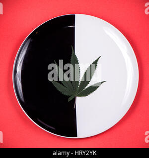 Detail of single cannabis leaf on a dish isolated - medical marijuana infused edibles concept Stock Photo