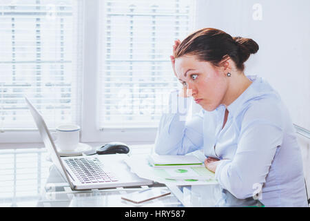 angry furious woman in modern business office looking at screen of laptop computer, anger, annoyed businesswoman Stock Photo