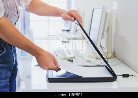 using scanner in office or library, closeup of hands scanning documents Stock Photo