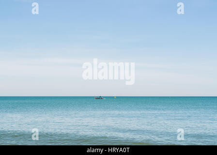 A lonely boat in the water of Mediterranean sea on sunny day at Malaga, Andalusia, Spain. Stock Photo