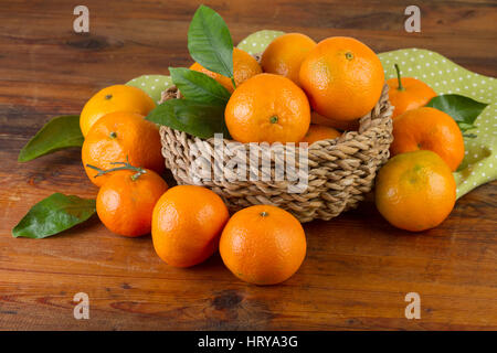 basket of tangerines with green napkin on old wooden background Stock Photo