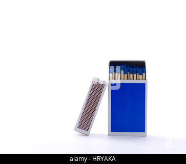 Close up photo of a blue matchbox with safety matches, isolated in front of a white background with a second matchbox leaning on its side Stock Photo
