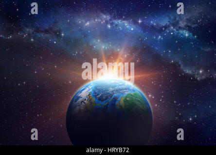 Illuminated face of a planet in outer space, a sunny light shining behind Stock Photo