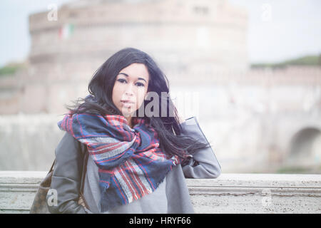 Beautiful longhair afro woman with thinkful expression in Rome Italy, concept of traveling, modern woman, contemporary. Stock Photo