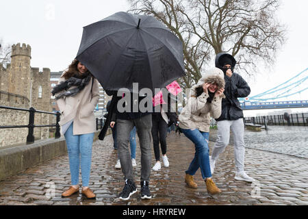 London, UK. 5th Mar, 2017. Tourists are caught in a heavy rain shower near the Tower of London. Credit: Vickie Flores/Alamy Live News Stock Photo