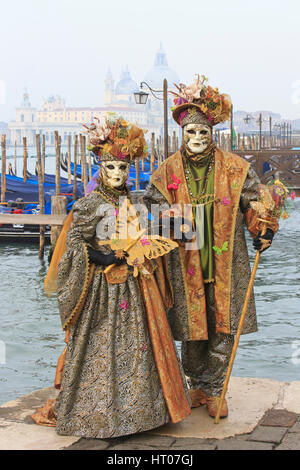 A couple in traditional Venetian costumes outside the Basilica di Santa Maria Della Salute during the Carnival of Venice, Italy Stock Photo