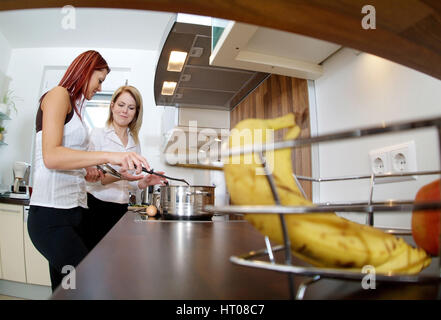 Zwei junge Frauen kochen gemeinsam - two young women cooking together Stock Photo