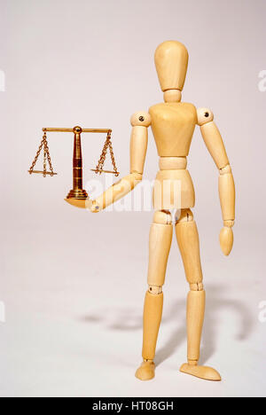 Holzpuppe mit Messingwaage, Symbolbild Gerechtigkeit - jointed doll with scale Stock Photo