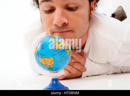 Junger Mann mit Miniatur-Globus - man with globe Stock Photo