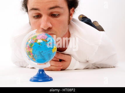 Junger Mann mit Miniatur-Globus - man with globe Stock Photo