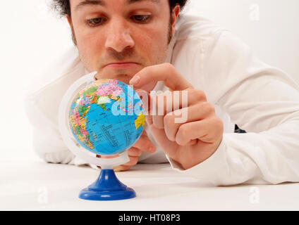 Junger Mann mit Miniatur-Globus - man with globe Stock Photo