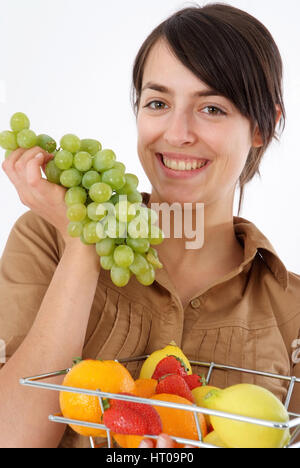 Junge Frau mit Obstkorb isst Weintrauben - young woman eats grapes Stock Photo