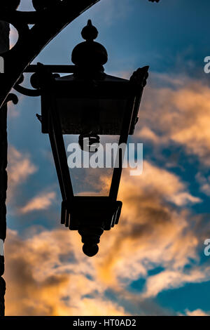 Lamp silhouette, Somerled Square, Portree, Isle of Skye, against golden glowing clouds on a winter's afternoon Stock Photo