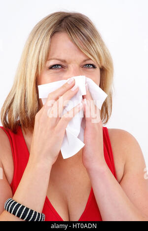 Frau schneuzt sich - woman blows her nose