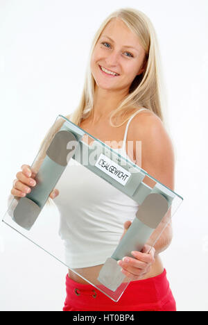 Schlanke, junge Frau mit K?rperwaage - young woman with scale Stock Photo