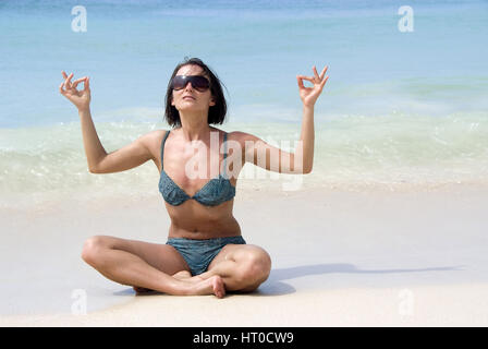 Frau macht Joga am Sandstrand - woman does yoga on the beach