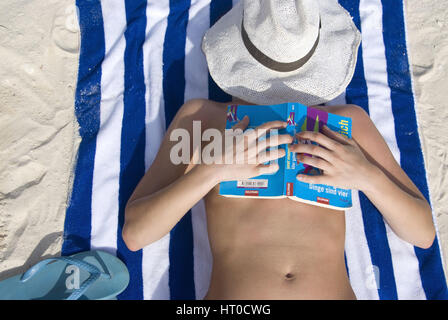 Frau entspannt mit Buch am Strand - woman with book relaxing on the beach Stock Photo