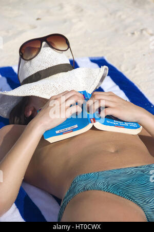 Frau entspannt mit Buch am Strand - woman with book relaxing on the beach Stock Photo