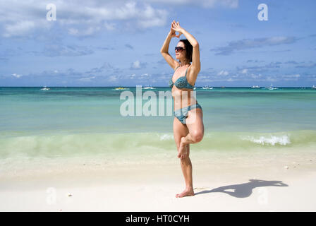 Frau macht Joga am Sandstrand - woman does yoga on the beach