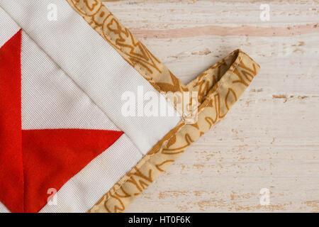 Part of kitchen tack in style patchwork on a white wooden background close up. color patterns from fabric rags on a cloth, handmade. Stock Photo