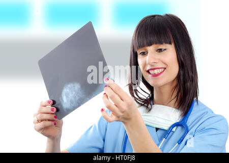 a young female doctor with stethoscope looking at patients x-ray Stock Photo