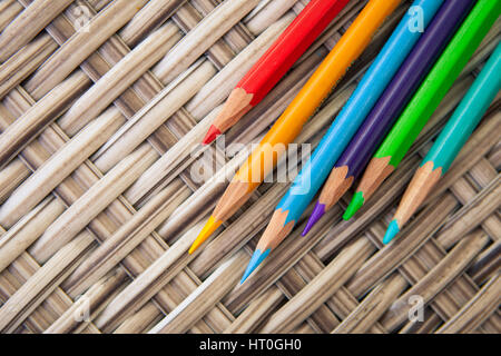 Wooden color pencils on a background of natural wicker table. Before the drawing Stock Photo
