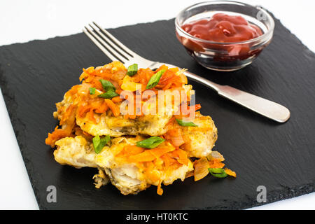 Greek style roast fish on black stone plate Stock Photo