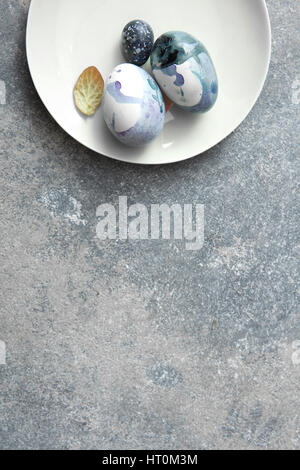 Easter eggs on a plate on a concrete table, copy space flat lay Stock Photo