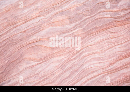 Layers of sandstone in Southern Utah, eroded into stripes of pink and white waves and curves. Stock Photo