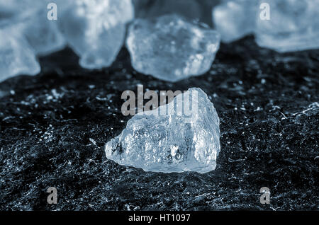 Extreme macro photography or detail grain of salt on black stone table Stock Photo