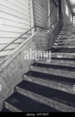 Industrial warehouse concrete staircase, black and white monochromatic wide angle lens image Stock Photo