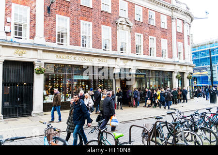 Bettys Café Tea Rooms customers queue queuing outside shop waiting for bettys famous tea room York city centre UK England exterior sign signs name Stock Photo
