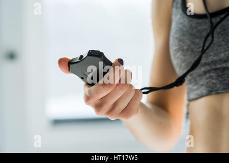 partial view of sporty woman holding stopwatch in hand Stock Photo