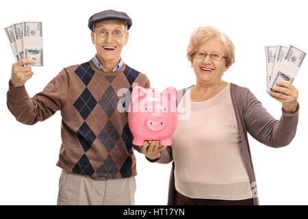 Cheerful senior couple with bundles of money and a piggybank isolated on white background Stock Photo