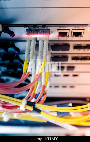 Fiber optic cable connect to ethernet switch mount on rack Stock Photo