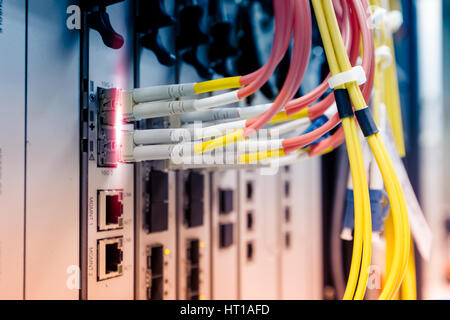 Fiber optic cable connect to ethernet switch mount on rack Stock Photo