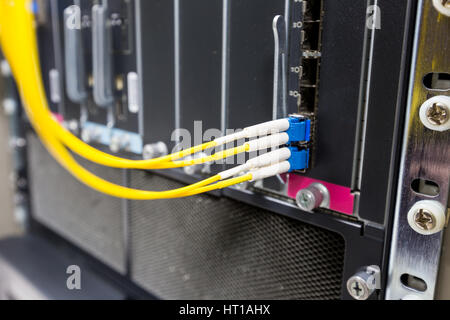 Fiber optic cable connect to ethernet switch mount on rack Stock Photo