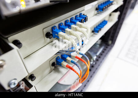 Fiber optic cable connect to ethernet switch mount on rack Stock Photo