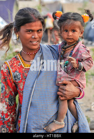 A young Rajasthani mother dresses her young son as a little girl Stock Photo