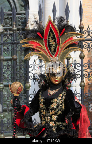 A lady outside the Venetian Arsenal in a traditional Venetian costume during the Carnival of Venice, Italy Stock Photo