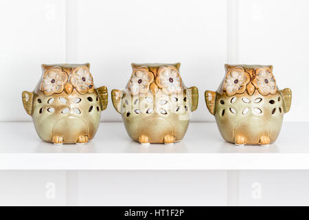 Decorative green owl candles on white shelf Stock Photo
