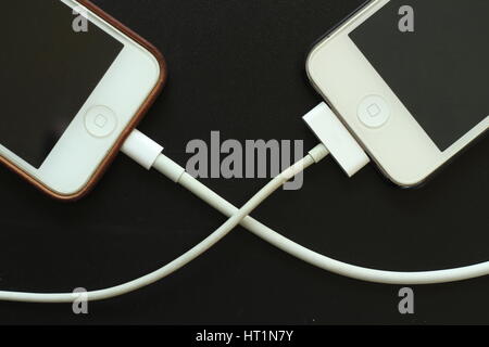 Smartphones connected cable, data transfer, communication link Stock Photo